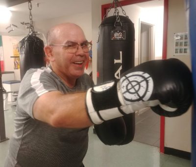 Homme agé pratique la boxe avec le sourire